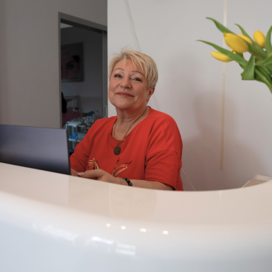 Lydia Chrenko sitzt am Empfangstresen des Kosmetikinstitutes Chrenko